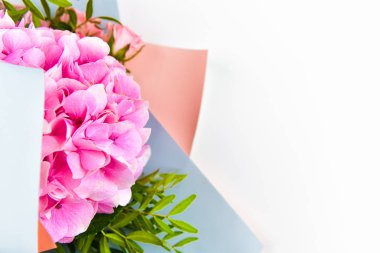 Beyaz arka planda pembe çiçek buketi. Hediye paketinde. Yazı için uygun bir yer. Kesmesi kolay. Yukarıdan bak. yakın plan.