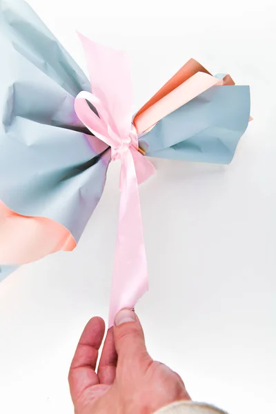 Concepto de regalo para las mujeres. La mano tira de la cinta. de un ramo de flores. lugar para escribir. vista desde arriba . — Foto de Stock