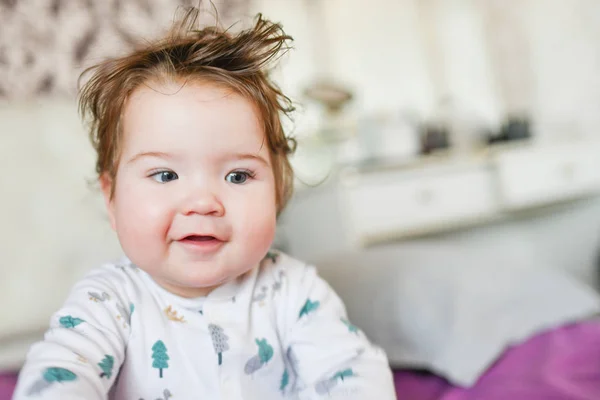 Schattige baby, van dichtbij. Portret van een kruipende baby op het bed in haar kamer — Stockfoto