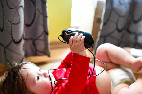 Criança pequena, primeiros passos na Internet, um bebê recém-nascido está segurando um mouse do computador. criança segura rato — Fotografia de Stock