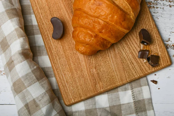 Čokoládové croissanty. na začátku dopoledne. Šálek kávy. Čerstvý francouzský croissant. Šálek kávy a čerstvé pečené croissanty na dřevěném pozadí. Pohled shora. — Stock fotografie