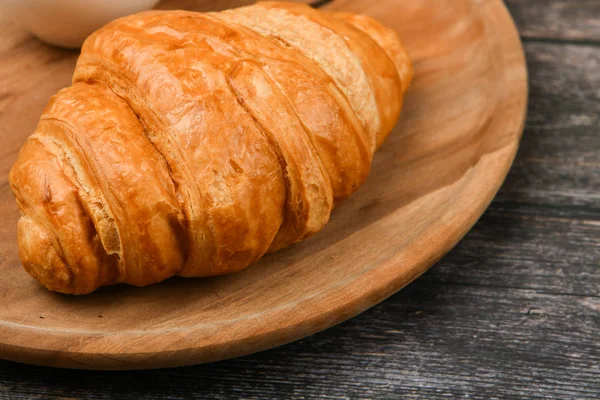 Croissant detailní záběr. Čerstvý francouzský croissant. Na dřevěné pozadí. Pohled shora. Ranní snídaně s croissantem. Francouzská snídaně — Stock fotografie