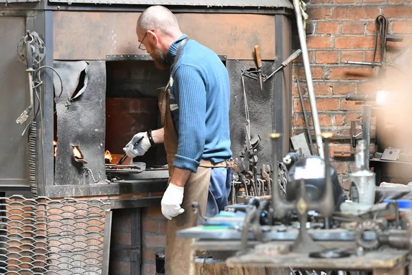 Demirci iş başında. Kızgın bir fırında çalışmak..