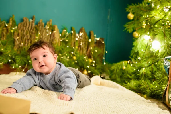 Bebê e conceito de Natal. Bebê com fundo de Natal na temporada de inverno, bebê saudável e conceito de inverno. Férias de Ano Novo. um presente debaixo da árvore . — Fotografia de Stock