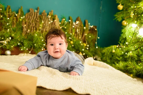 Concept de bébé et de Noël. Bébé avec fond de Noël en saison d'hiver, bébé sain et concept d'hiver. Les vacances du Nouvel An. un cadeau sous l'arbre . — Photo