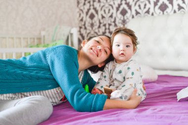 Anne ve çocuk için sevgi. Yatakta. Mutluluk duyguları. Bebeği öpmek ve sarılmak. Güzel bir kadın kucağında yeni doğmuş bir bebeği tutuyor. 
