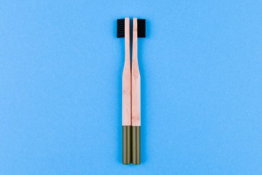 Mavi arka planda ahşap diş fırçası. Mavi arka plandaki ahşap diş fırçasını kapat. eko fırçası.