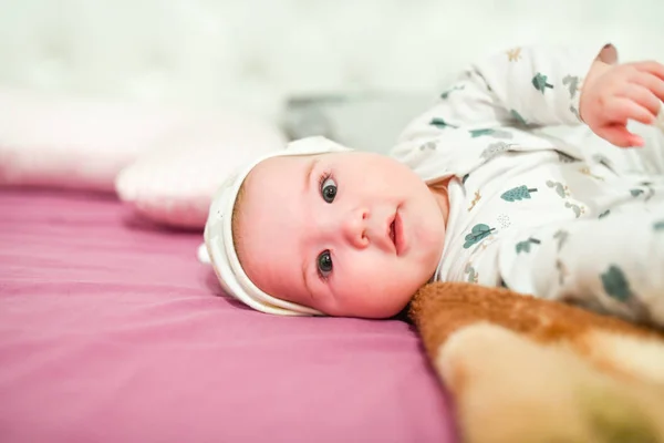 Barnet i hatt hemma. Söt baby i hatt på sängen ha kul — Stockfoto