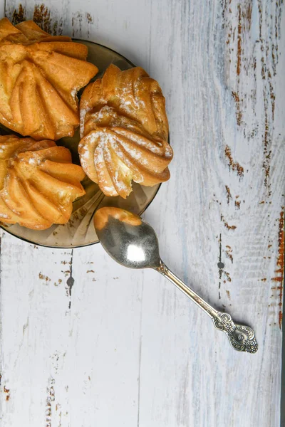 Pastelaria choux e colher, em fundo de madeira. Fechar Choux Cream. Com uma colher de metal e garfo no fundo — Fotografia de Stock