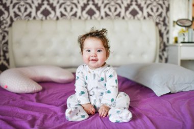 Kestirdikten sonra mutlu bir bebek. Sağlıklı uyku, güçlü bir çocuğun garantisi. Tatlı küçük erkek bebek, banyodan sonra yatakta dinleniyor, mutlu bir şekilde gülümsüyor, gündüz vakti. 