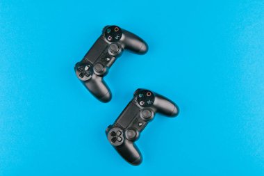 Oyun kumandası. Playstation. mavi arkaplan görünümünde. Playstation 4 'lü yeni Sony Dualshock 4. Sekizinci neslin Sony Playstation 4 oyun konsolu