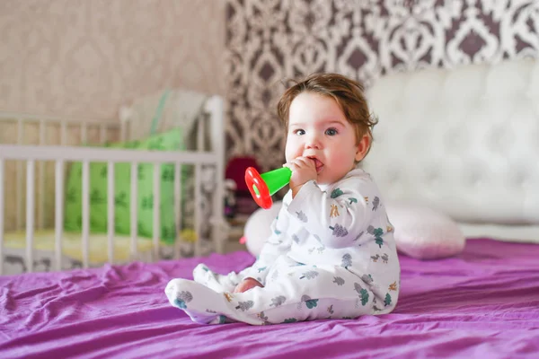 Dítě okusuje hračku. detailní portrét malá roztomilá dívka s velkýma modrýma očima s hračkou v ruce, kousne teether hračka — Stock fotografie