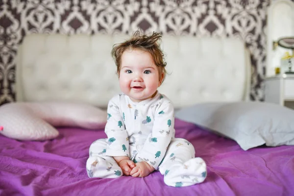 happy baby after a nap. healthy sleep, the guarantee of a vigorous child. Cute little baby boy, relaxing in bed after bath, smiling happily, daytime