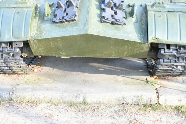 タンクホイールを閉じます。重戦車の鉄軌道。重戦車の鉄の毛虫と車輪。地面に立つタンクの緑の毛虫の正面部分の眺めwi — ストック写真