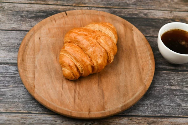 Clausura croissant. Croissant francés fresco. A sobre el fondo de madera. Vista desde arriba. Desayuno por la mañana con croissant. Desayuno francés — Foto de Stock