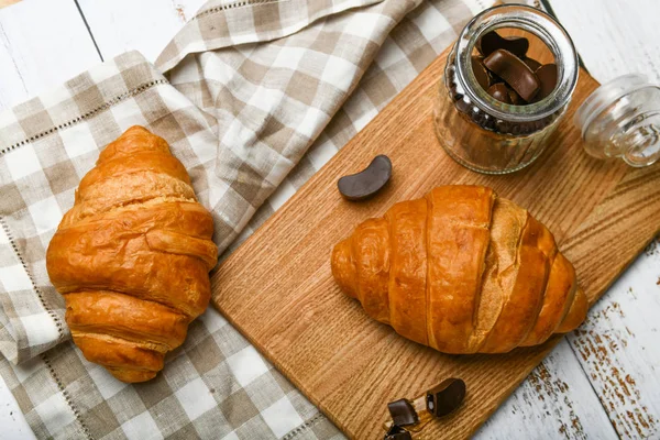 Francouzský čokoládový croissants top view. na začátku dopoledne. Čerstvý francouzský croissant. Šálek kávy a čerstvé pečené croissanty na dřevěném pozadí. Pohled shora. — Stock fotografie