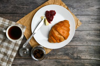 ay çörekli kahve. Sabahın başlangıcında. Bir fincan kahve. Taze Fransız kruvasanı. Kahve fincanı ve ahşap arka planda taze pişmiş kruvasan. Yukarıdan görüntüle.
