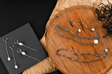 Zincirli gümüş küpeler. Yakın plan. Tahta bir tezgahta yatıyordu. Yukarıdan bak. Mücevher ve mücevher kavramı. Kadınlar için hediyeler. Alışveriş. El işi.