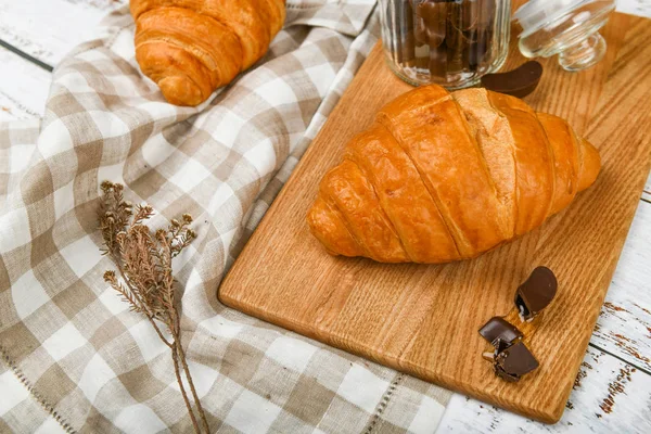 Chocolate croissants. the beginning of the morning. A cup of coffee. Fresh french croissant. Coffee cup and fresh baked croissants on a wooden background. View from above. — Stock Photo, Image