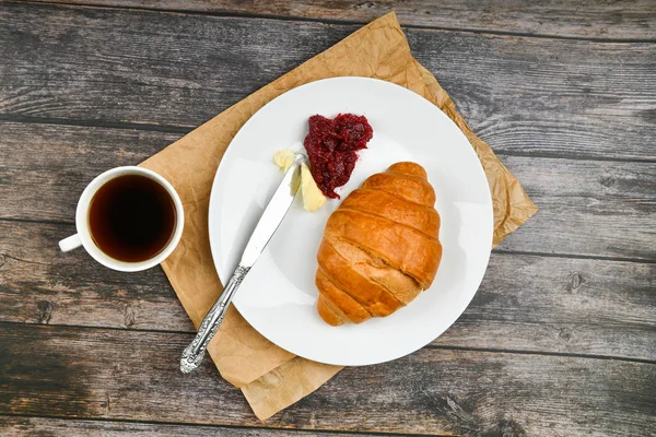 Café da manhã com croissant. o início da manhã. Croissant francês fresco. xícara de café e croissants assados frescos em um fundo de madeira. Vista de cima. Café da manhã com croissant e bacalhau — Fotografia de Stock