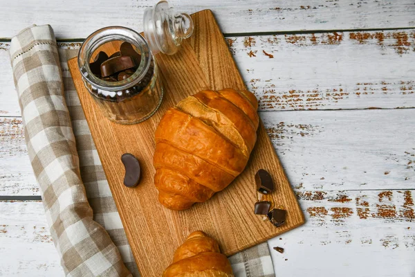 Cazadoras francesas de chocolate con vistas a la cima. el comienzo de la mañana. Croissant francés fresco. Cafetería y croissants recién horneados en un entorno de madera. Vista desde arriba.. — Foto de Stock