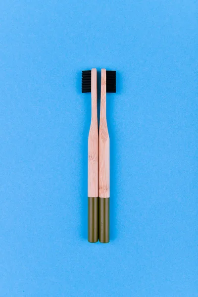 Cepillo de dientes de madera sobre fondo azul. Cierre el cepillo de dientes de madera sobre un fondo azul. cepillo ecológico . — Foto de Stock