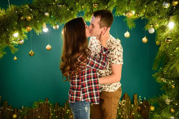 Pareja enamorada cerca de fondo navideño. Pareja joven besándose cerca del árbol de Navidad. Bajo perfil. Silueta —  Fotos de Stock