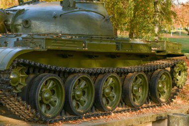 Tank tekerlekleri yakın çekim. Ağır bir askeri tankın demir izleri. Demir tırtıllar ve askeri bir tankın tekerlekleri. Su tankının yeşil tırtılının ön kısmının görüntüsü.