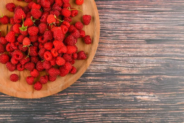 Hallon på en träplatta. Trä rund, platt tallrik. på en träbakgrund. Trä block med orden C-vitamin, färska frukter i bakgrunden, hälsosam mat eller kost koncept. Utsikt ovanifrån. — Stockfoto