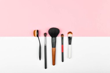 Beyaz ve pembe arka planda makyaj fırçaları. Makyaj fırçaları. Geçmişi. Kopyalama alanı var. güzellik ve kozmetik blog yazarı