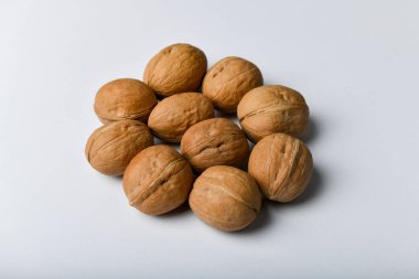 Beyaz arka planda cevizler. Ceviz manzarasını kapat. Cevizler 4 su, 15 protein, 65 yağ ve 7 diyet lif dahil 14 karbonhidrattır. Referans olarak 100 gram..