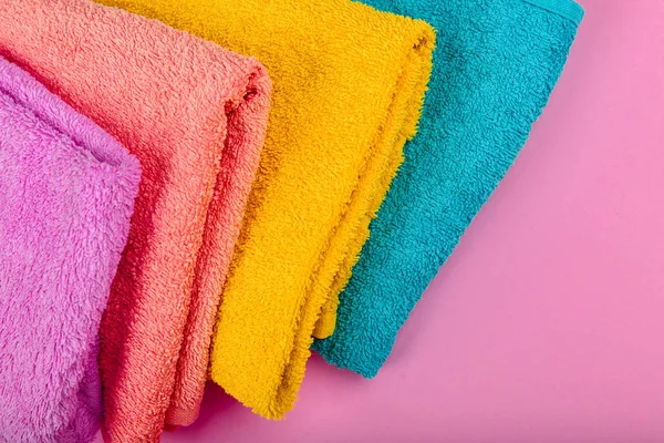 Asciugamani multicolore su sfondo rosa. Asciugamani rosa, beige, giallo e blu. Posto per iscritto. Ordine del Parlamento. — Foto Stock