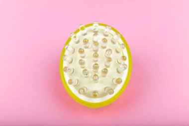 Pembe arka planda masaj fırçası. Jel fırçası yeşili. Yukarıdan bak. Farklı açılardan. Masaj fırçası. Selülit önleyici masaj fırçası. Pembe arka planda. Masaj aksesuarı.