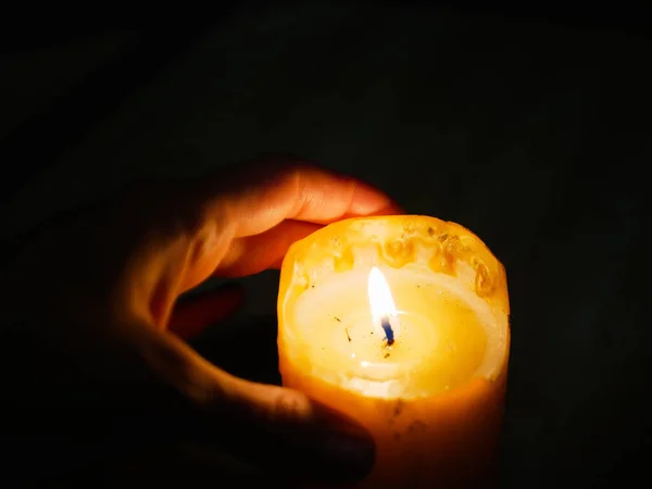 Kaars in de handen op een donkere achtergrond. tijdens het festival van het licht — Stockfoto