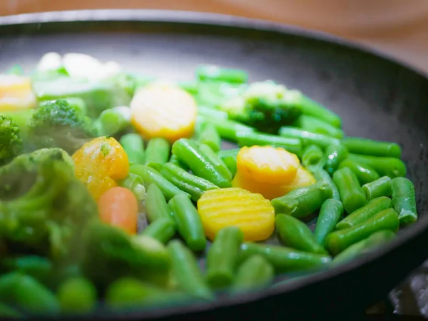 Gemüse in einer Pfanne in Großaufnahme gebraten. Dampf kommt. Defokussierung. Vegetarier kaum. Öko-Lebensmittel. — Stockfoto