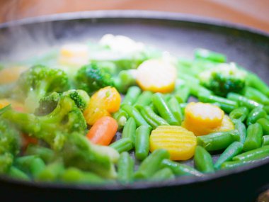 Tavada kızartılmış sebzeler. Buhar geliyor. Defoktus. Neredeyse vejetaryen. Çevre yiyecekleri.