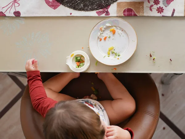 Dítě u stolu jí pohled shora. pojetí dětství, jídla a lidí - malé dítě jíst zdravou snídani k večeři v restauraci nebo kavárně — Stock fotografie