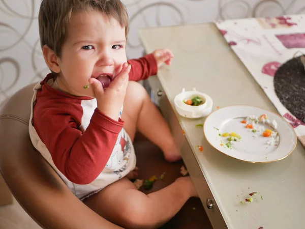 餐桌旁的孩子吃蔬菜.童年、食物和人的概念-幼儿吃饭时吃健康的早餐 — 图库照片
