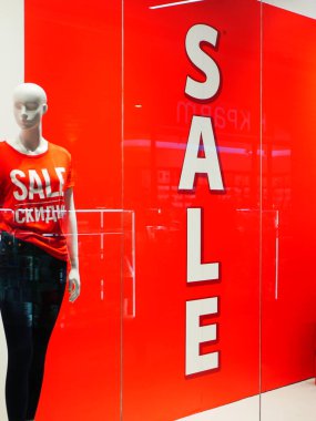 Yazıt satışının arka planında bir vitrindeki kadın mankeni.