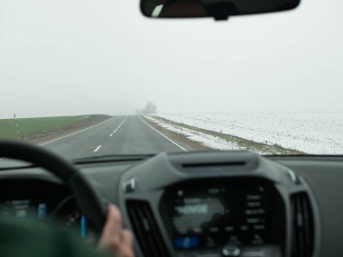 Sisli havada araba sürüyorum. Sisli yol. Direksiyonda kötü hava, sisli kır yolu. Tehlikeli bir yol. Sürücü koltuğundan görüntü