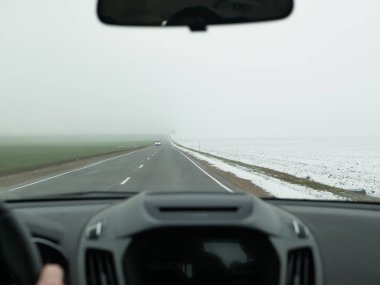Araba sise karışıyor. Ön manzara. Güvenli sürüş değil. Araba siste hızla gidiyor, yolcu kompartımanından görüntü geliyor..