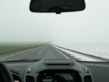 Sisli havada araba sürüyorum. Sisli yol. Direksiyonda kötü hava, sisli kır yolu. Tehlikeli bir yol. Sürücü koltuğundan görüntü