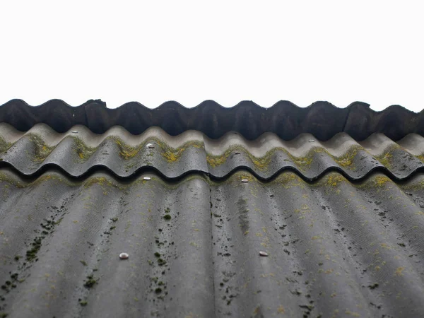家の古いスレート屋根。家を覆う古いと苔で覆われた波状の頁岩の屋根 — ストック写真
