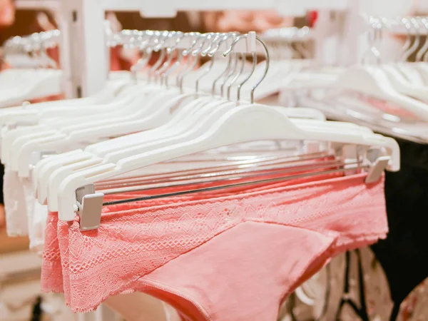 El ropa interior de las mujeres está colgando en las colgadoras de las tiendas. Womens bras a la venta en el mercado. Una variedad de sujetador colgando en la tienda de ropa interior. Publicidad, venta, concepto de moda. — Foto de Stock