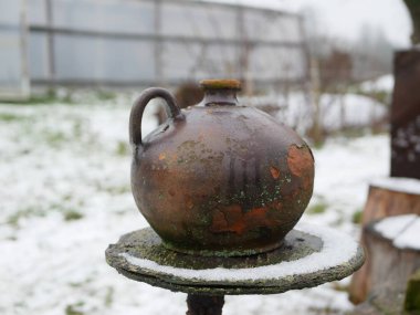 Kil sürahisi. Kışın çitin üzerindeki kil sürahi..