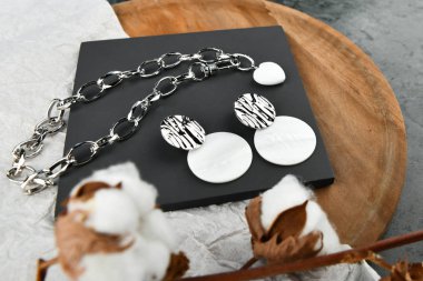 Kadınlar için gümüş el yapımı mücevherler. Gümüş zincirli kalp şeklinde bir kolye. Sevgililer Günü için dekorasyon. Ahşap arka planda zincirler. Yukarıdan görüntüle.