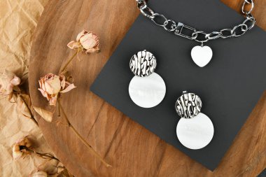 Gümüş zincirli, kalp şeklinde bir kolye. Tüm aşıkların günü için süslemeler. Tahta arka planda zincirler. Yukarıdan görüntüle. 