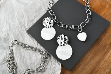 Gümüş zincirli, kalp şeklinde bir kolye. Tüm aşıkların günü için süslemeler. Tahta arka planda zincirler. Yukarıdan görüntüle. 