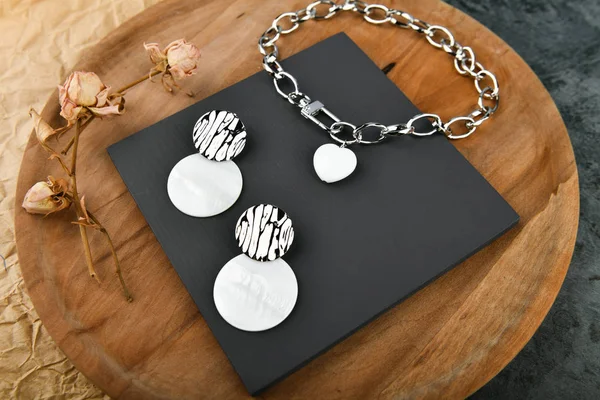 Kadınlar için gümüş el yapımı mücevherler. Gümüş zincirli kalp şeklinde bir kolye. Sevgililer Günü için dekorasyon. Ahşap arka planda zincirler. Yukarıdan görüntüle.