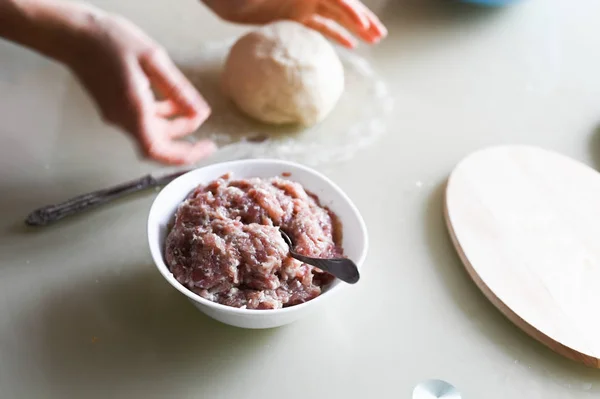 Testo con carne picada. Las manos arrugan la masa de cerca. Preparación manual de la prueba. Hornear en casa. Albóndigas y empanadillas de cocina. — Foto de Stock